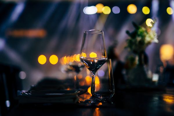 Ein Glas Wein und verschwommene Lichter im Hintergrund.