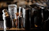Shaker, Jigger und Gläser in einer Bar.