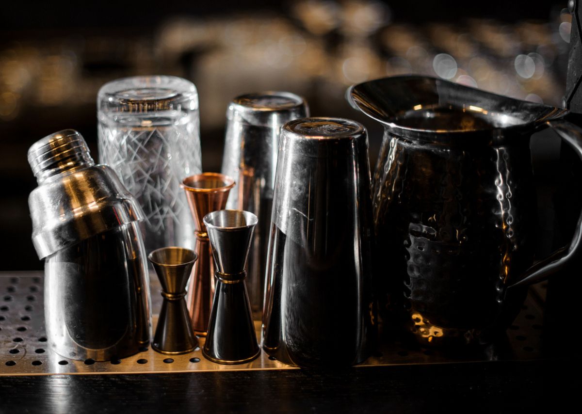 Shaker, Jigger und Gläser in einer Bar.